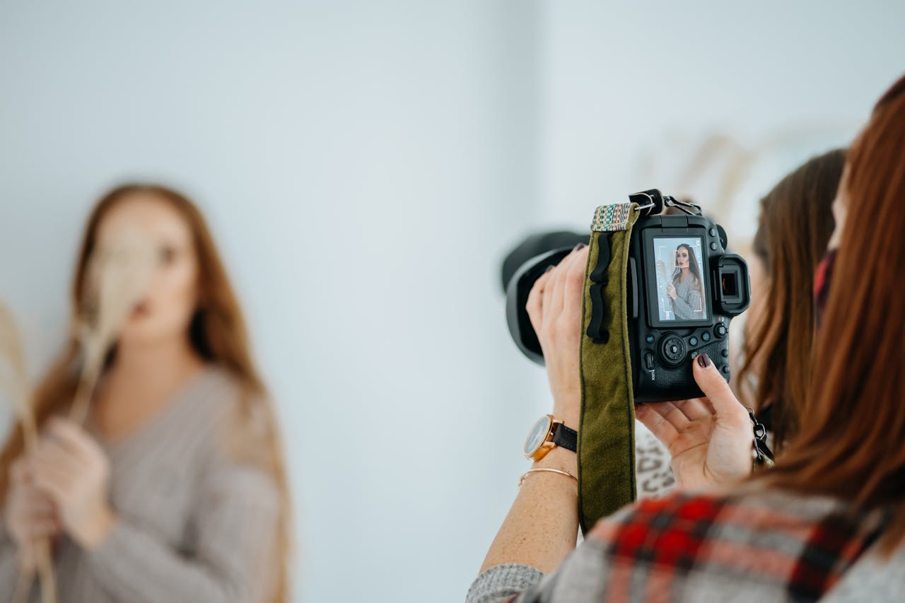 Photographer capturing a model in a studio with a DSLR, focusing on creative portrait photography techniques.